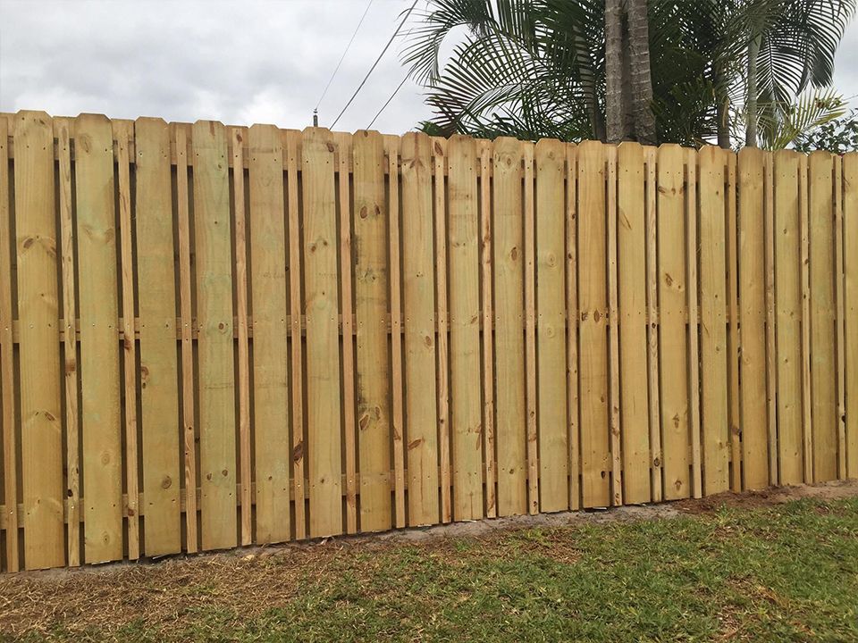 A wooden fence is sitting in the middle of a lush green field.