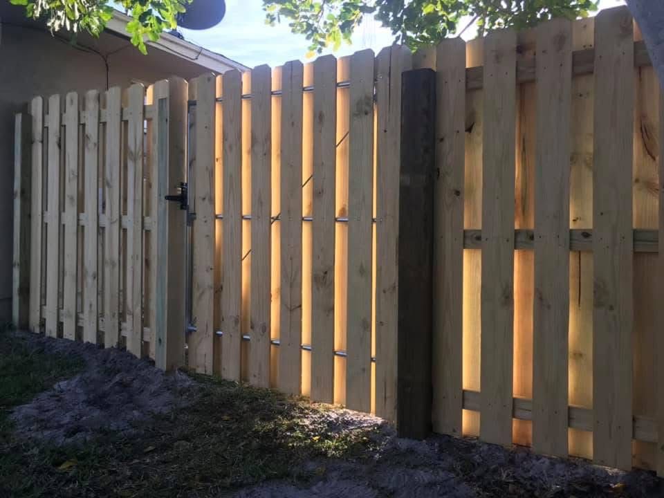 A wooden fence with a gate in the backyard