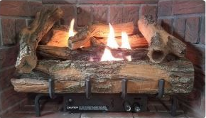 Gas fireplace with faux logs and flames, set in a brick hearth.