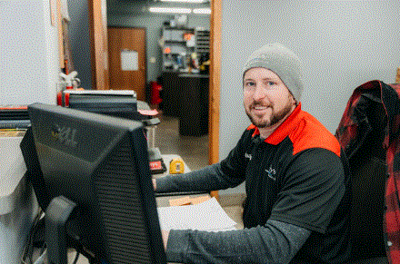 A man is sitting at a desk in front of a computer.