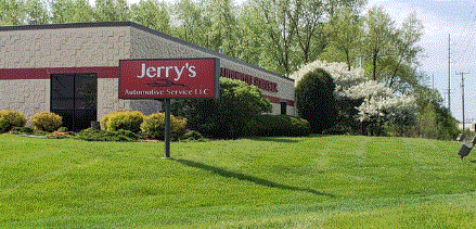 Jerry's Auto Service is sign in front of a brick building and green lawn.