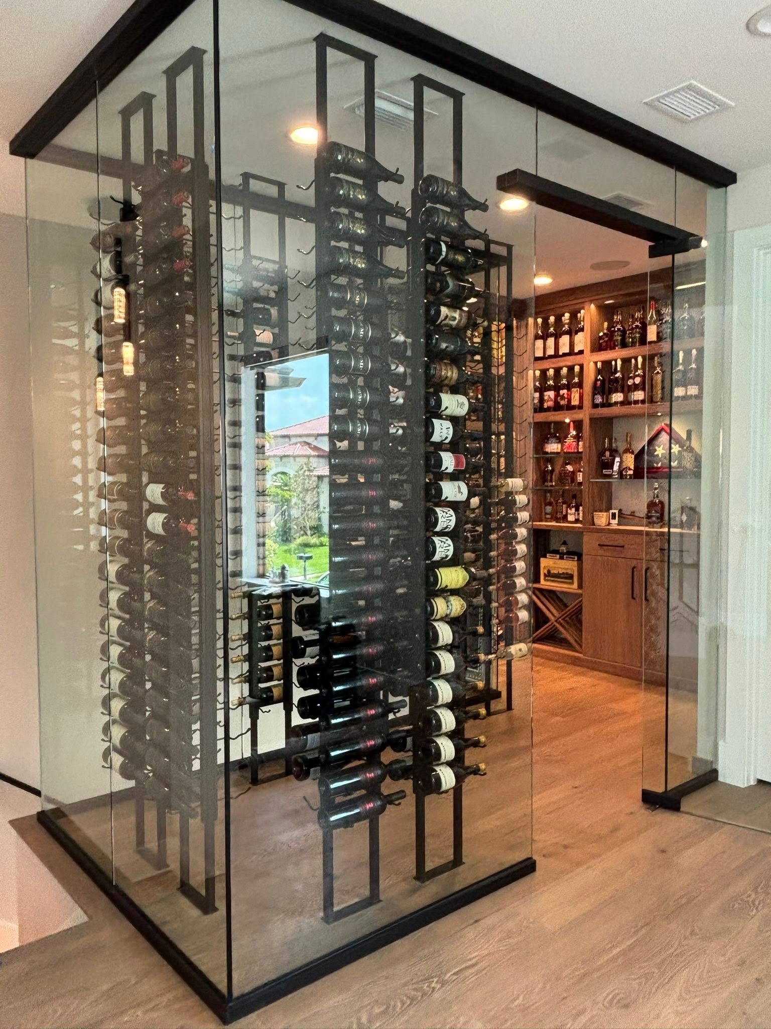 Modern wine cellar with glass-enclosed racks and bottles in a stylish room