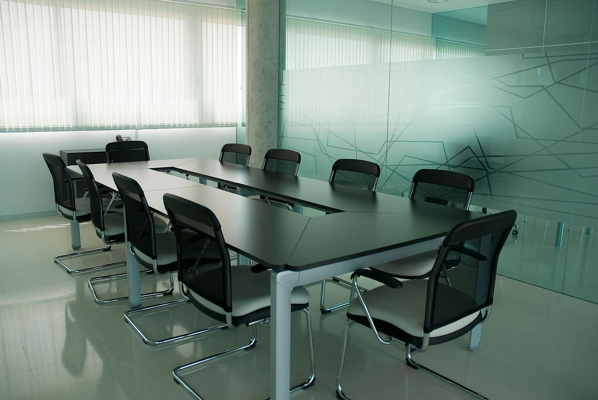 Modern conference room with a long black table and black chairs