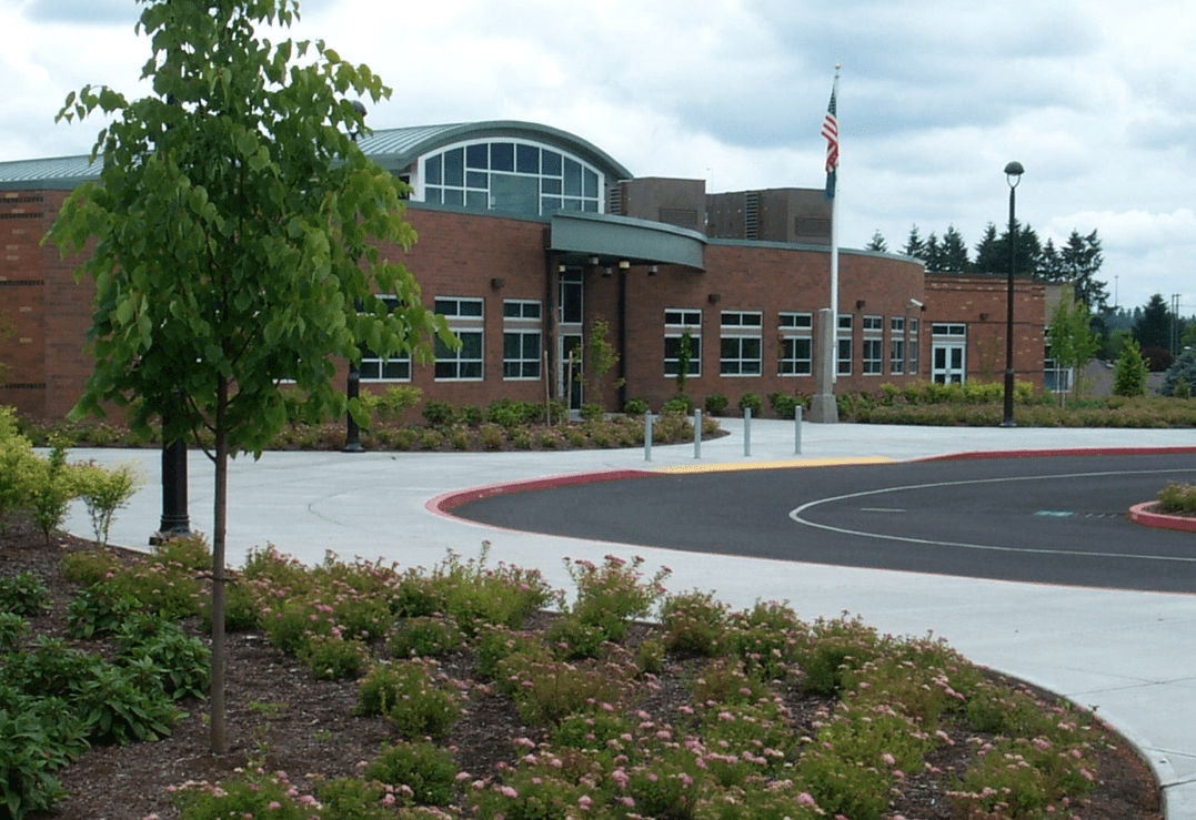 Red brick school building with a circular driveway and landscaping.