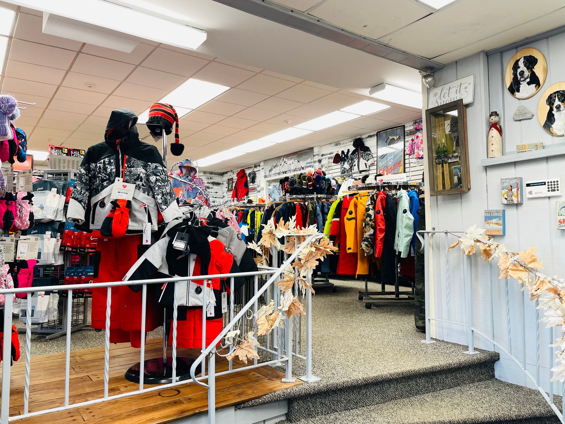 A store filled with clothes and a mannequin wearing a santa hat.