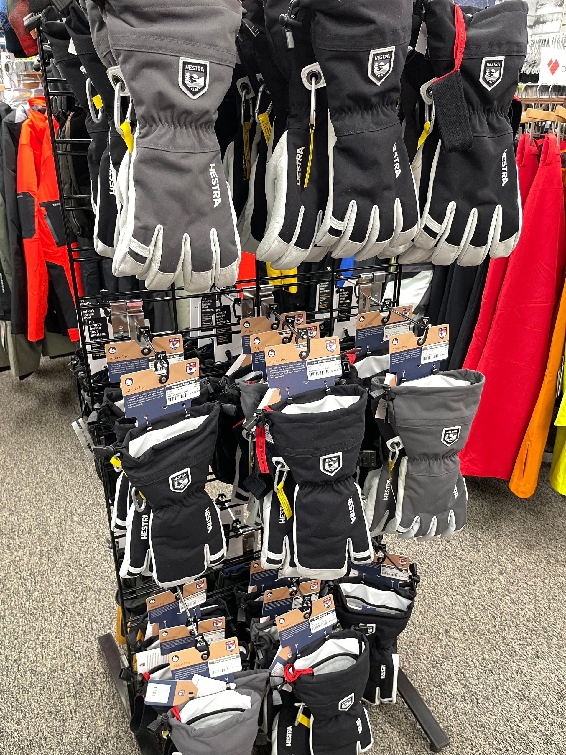 A bunch of gloves are hanging on a rack in a store.