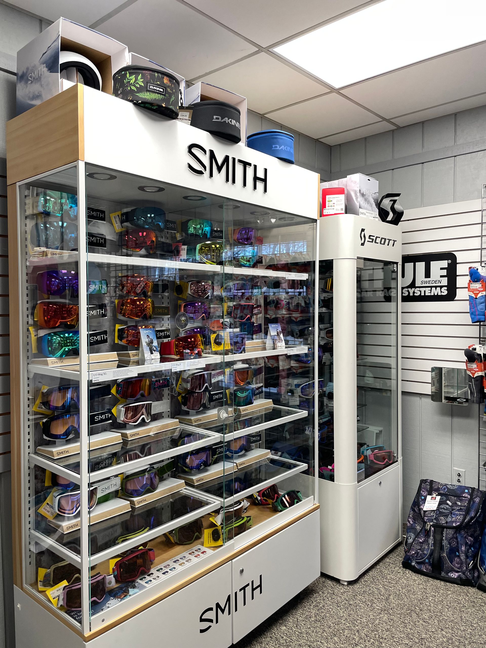 A display case filled with sunglasses and helmets in a store.