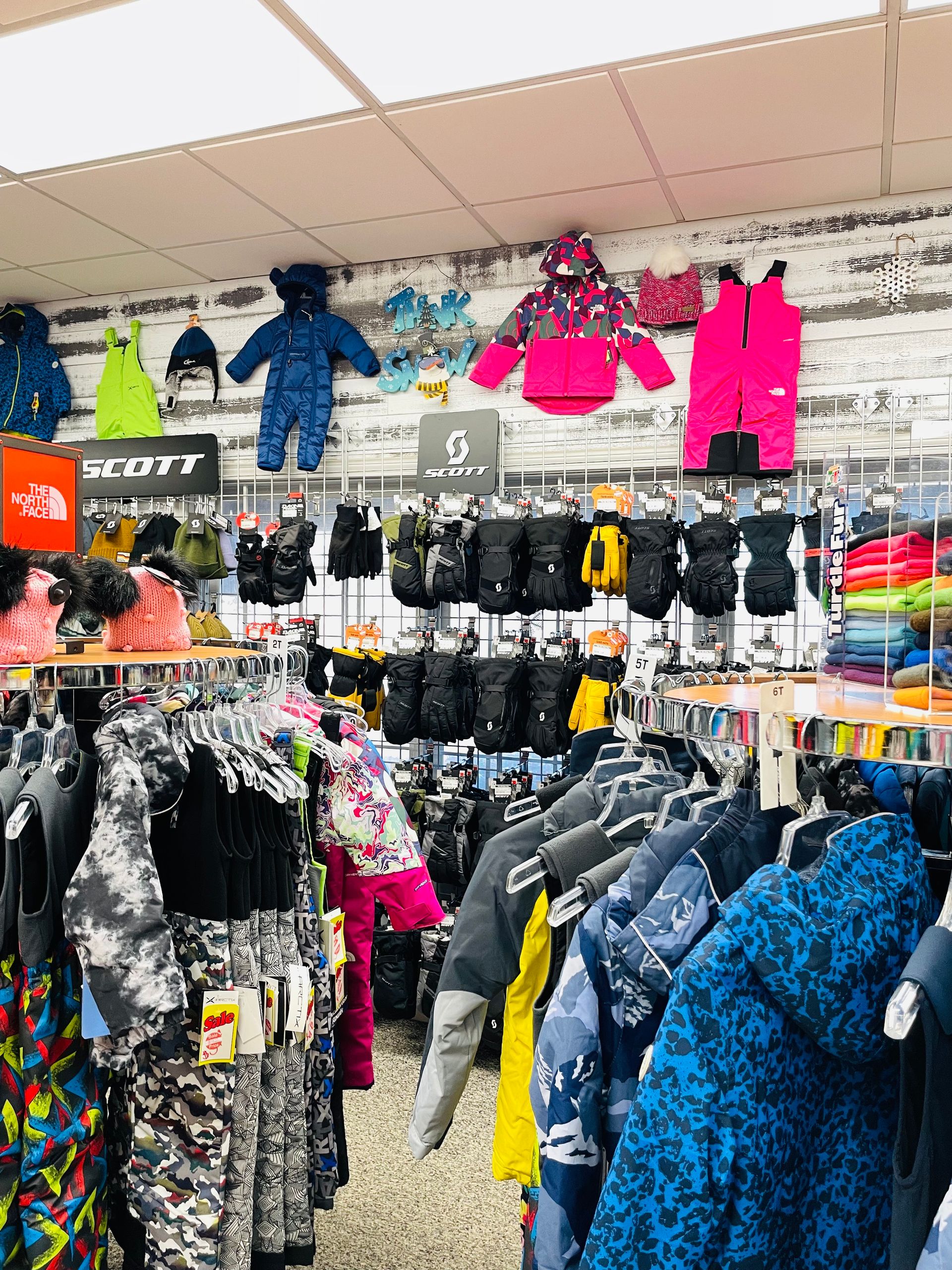 A store filled with lots of clothes hanging on racks.