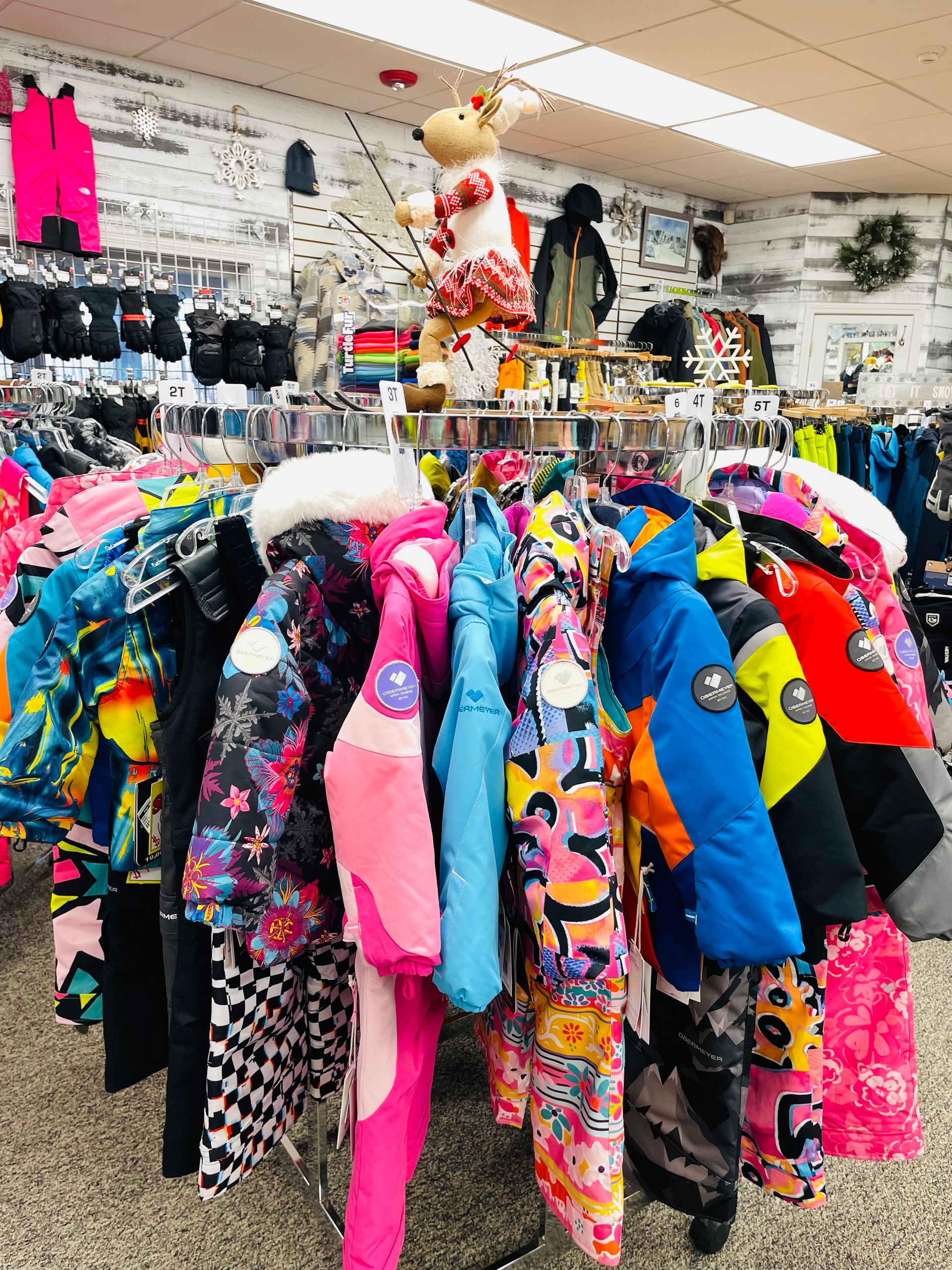 A bunch of jackets are hanging on a rack in a store.