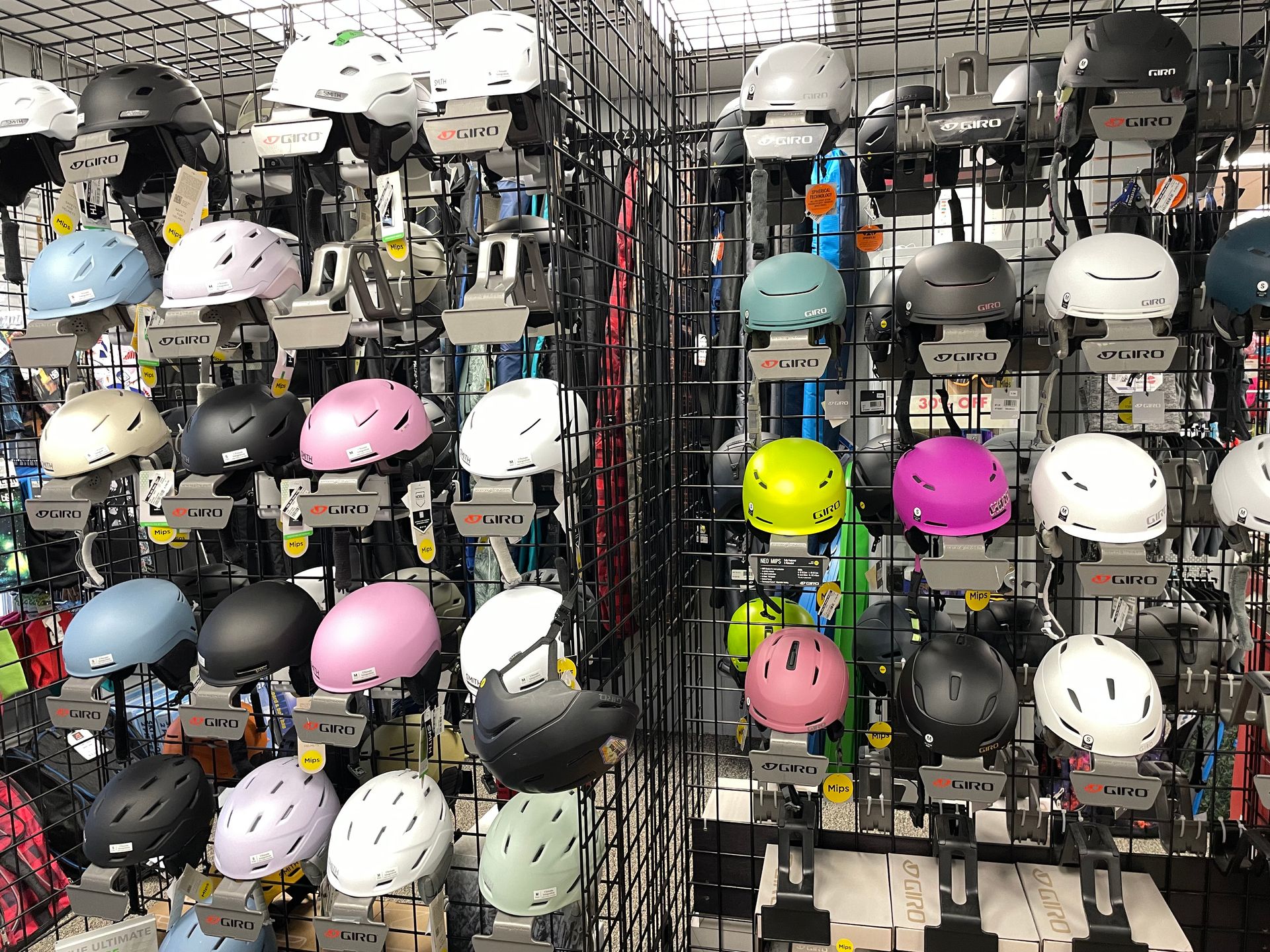 A bunch of helmets are hanging on a rack in a store.