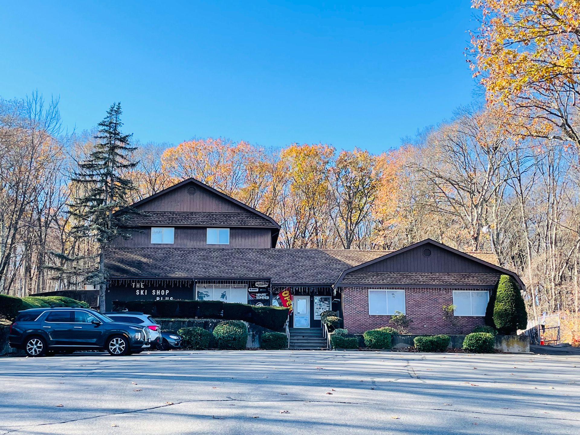 A large house with a lot of cars parked in front of it.