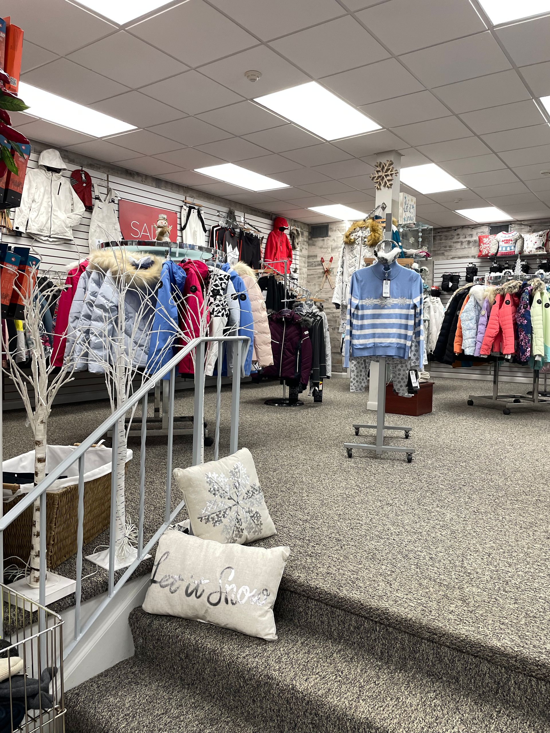 A store filled with lots of clothes and stairs leading up to it.