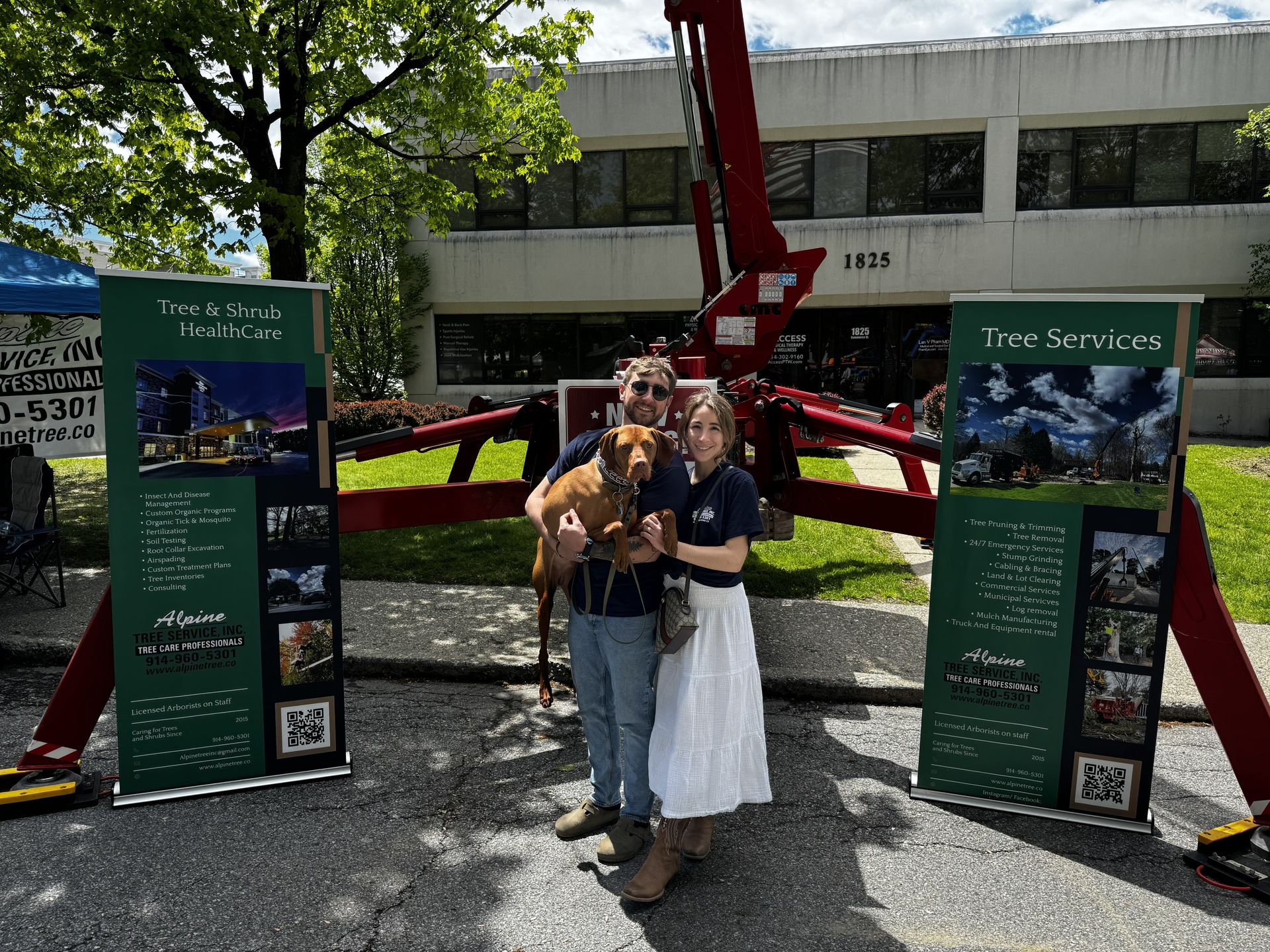 A couple stands with a dog between two large vertical 
