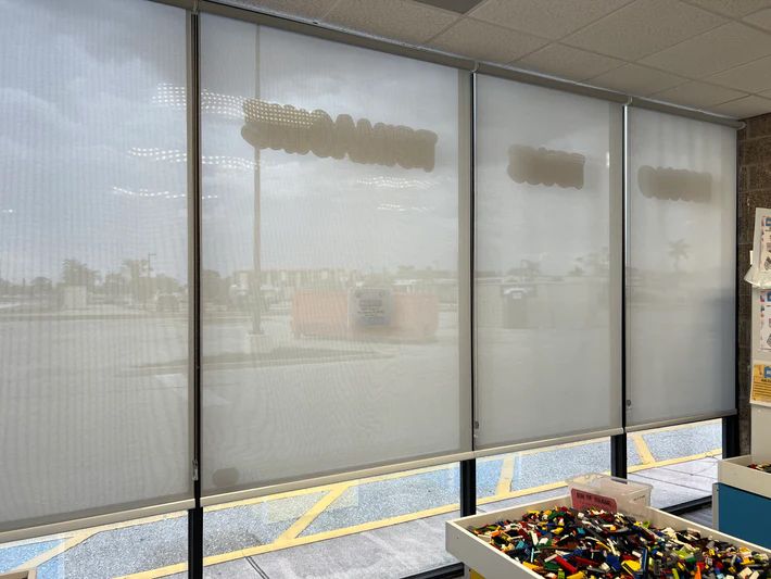 A room with a lot of windows and a table with lego on it.