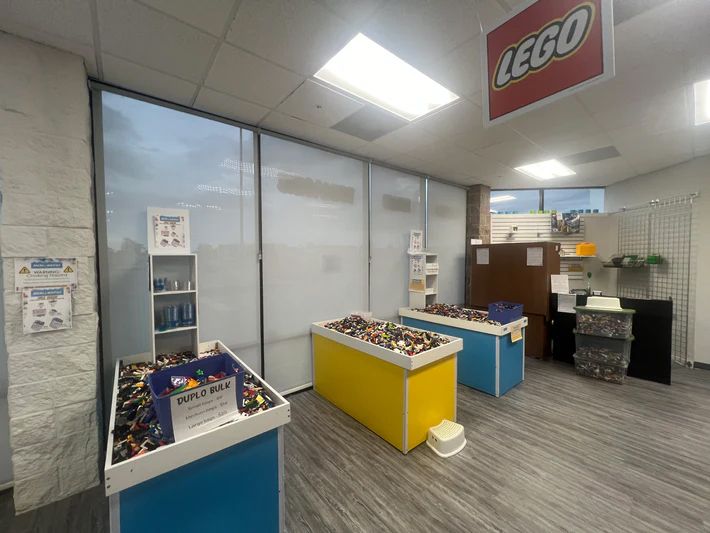 A room with tables and a sign that says lego on it.