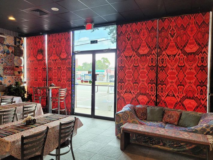 A restaurant with tables, chairs, and a couch.