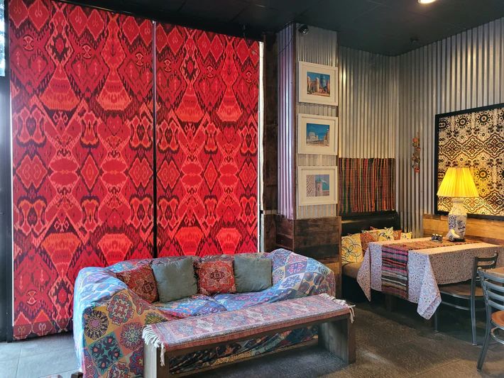 A living room with a couch, bench, table, and chairs.