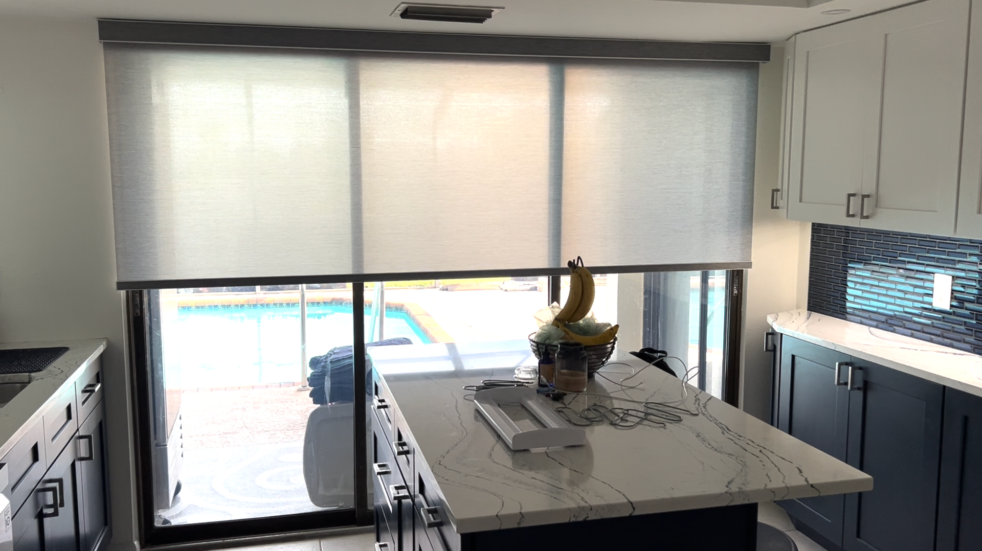 A picture of a kitchen with a large island and sliding glass doors.