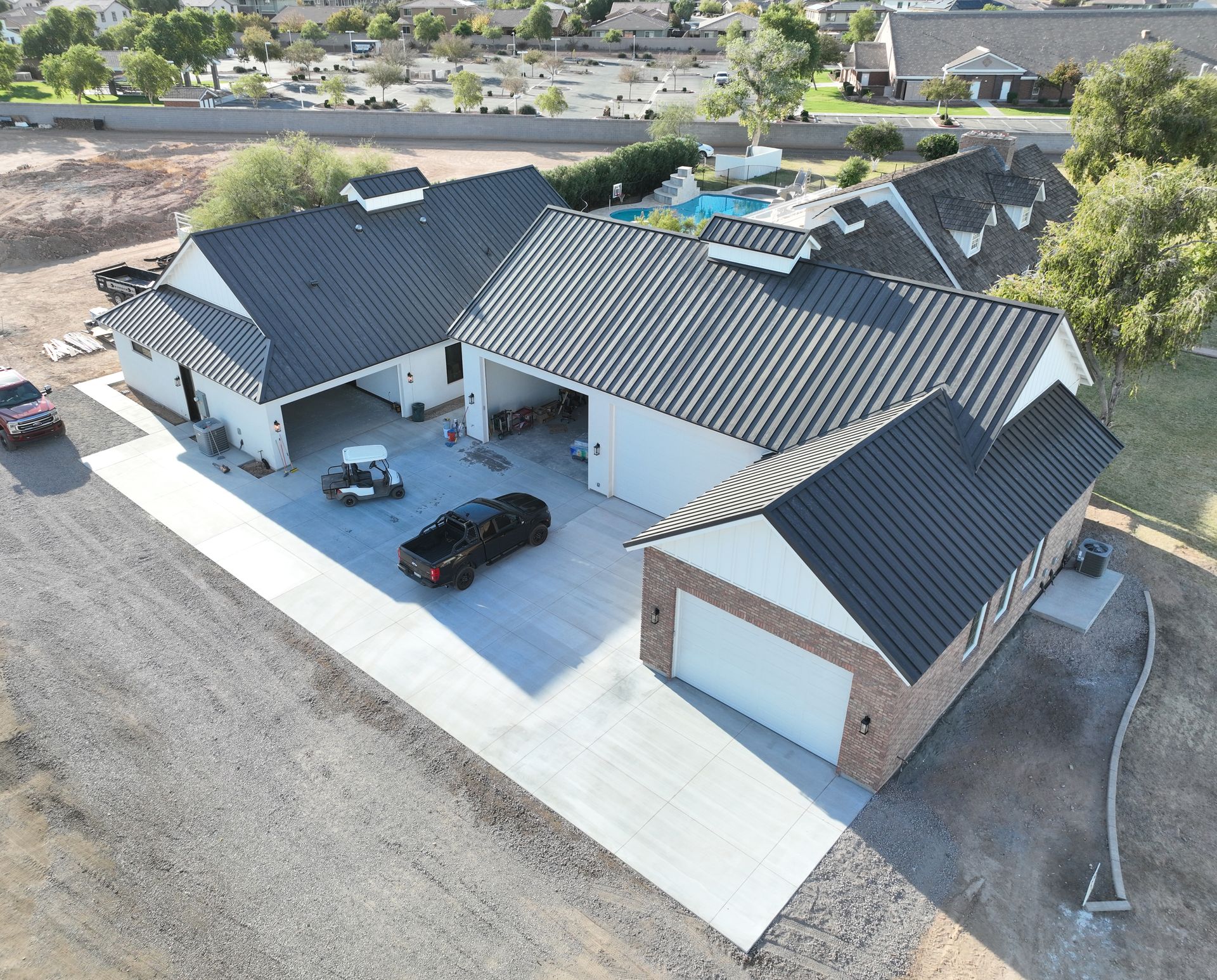 An aerial view of a house with a black metal roof.
