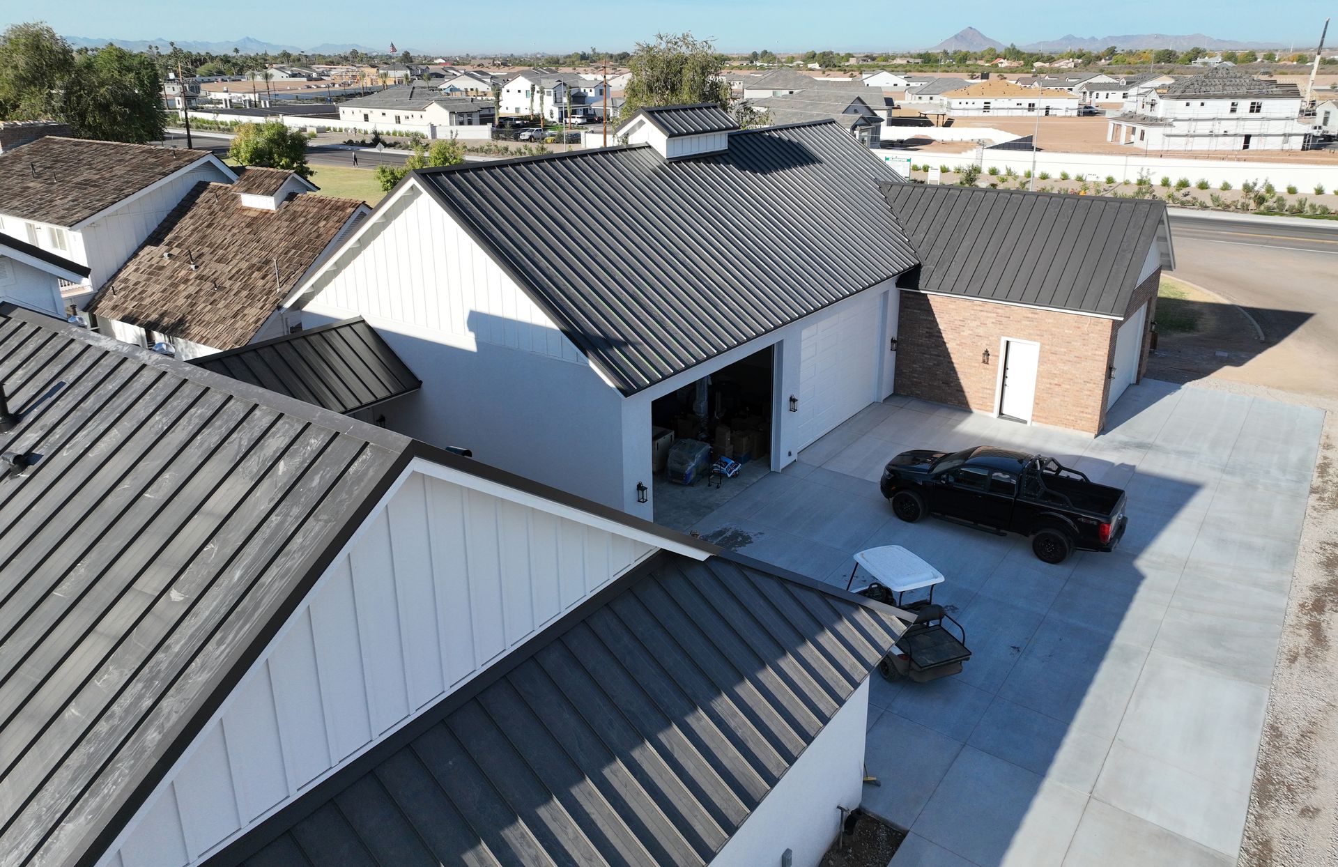 An aerial view of a house with a black metal roof.