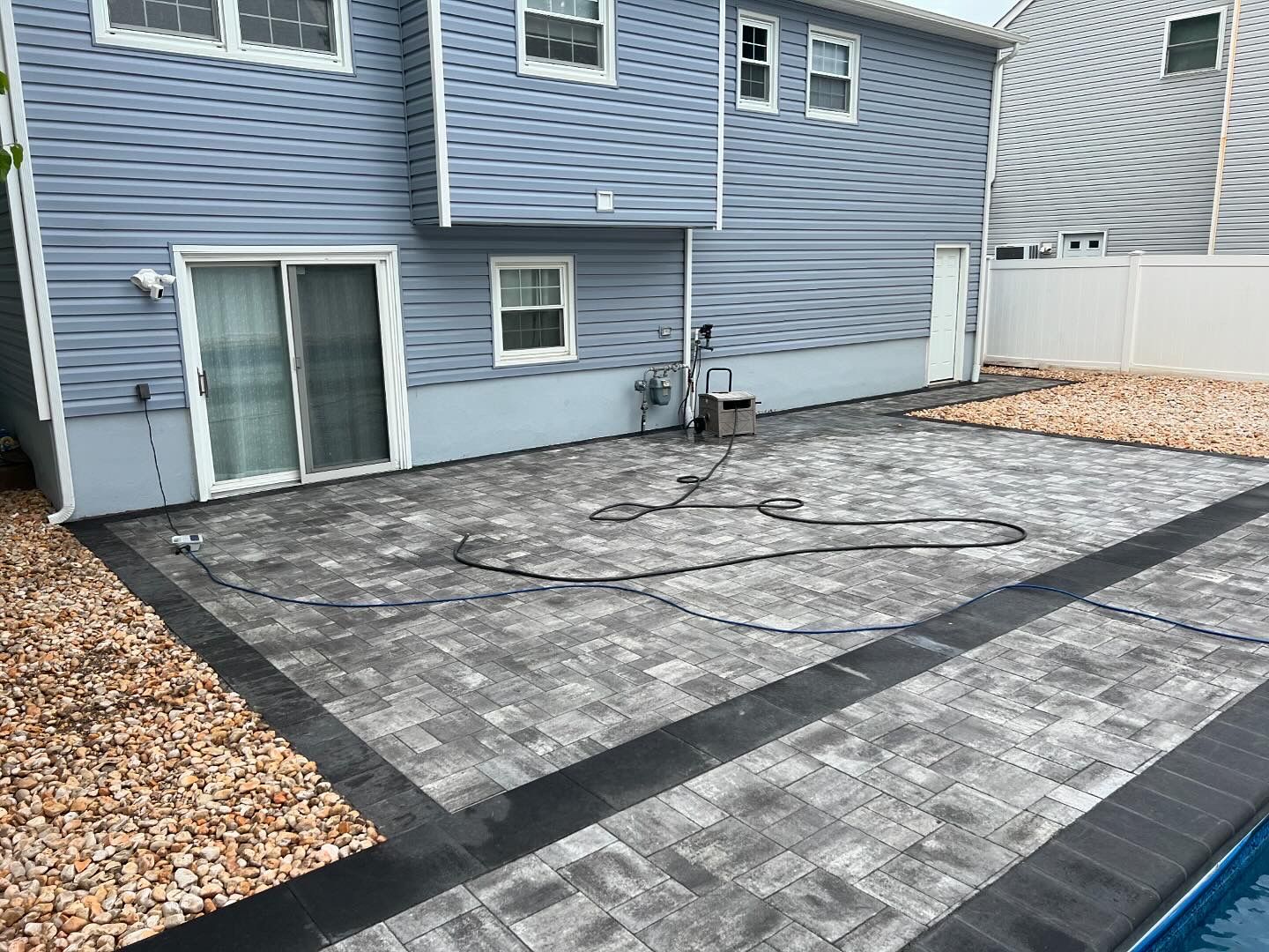 A house with a patio and a pool in front of it.