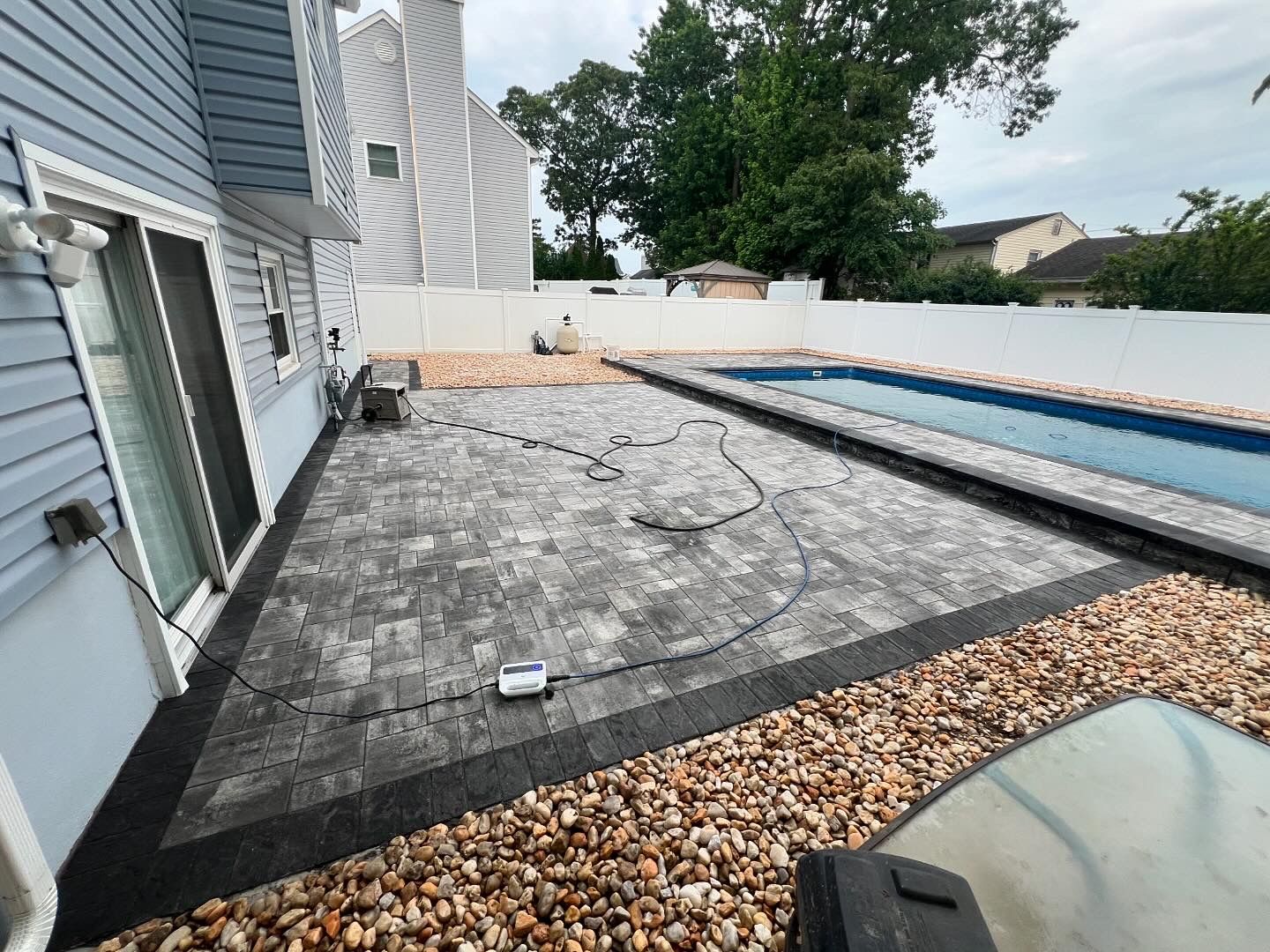 A patio with a pool in the backyard of a house.