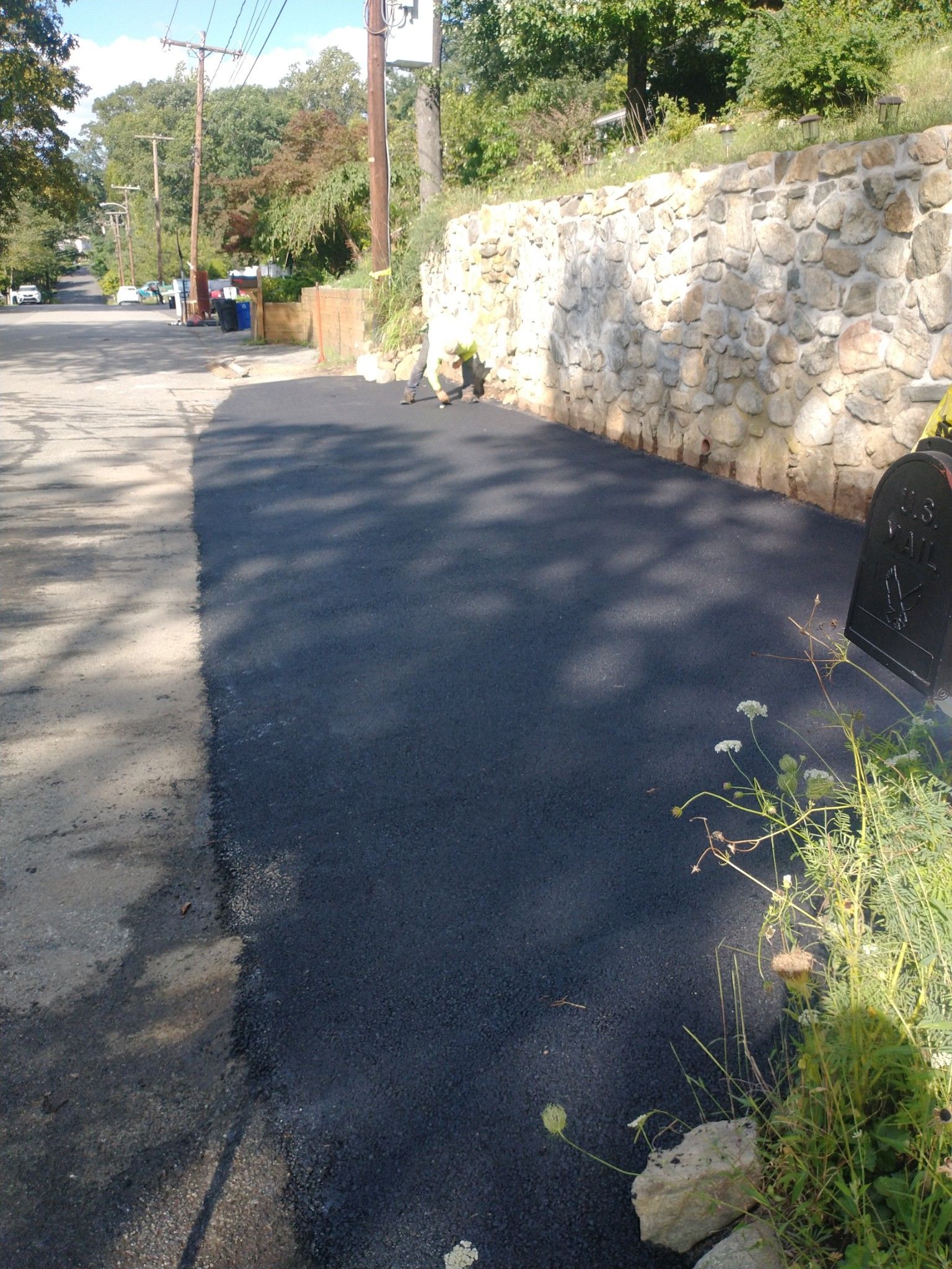 A road with a stone wall on the side of it