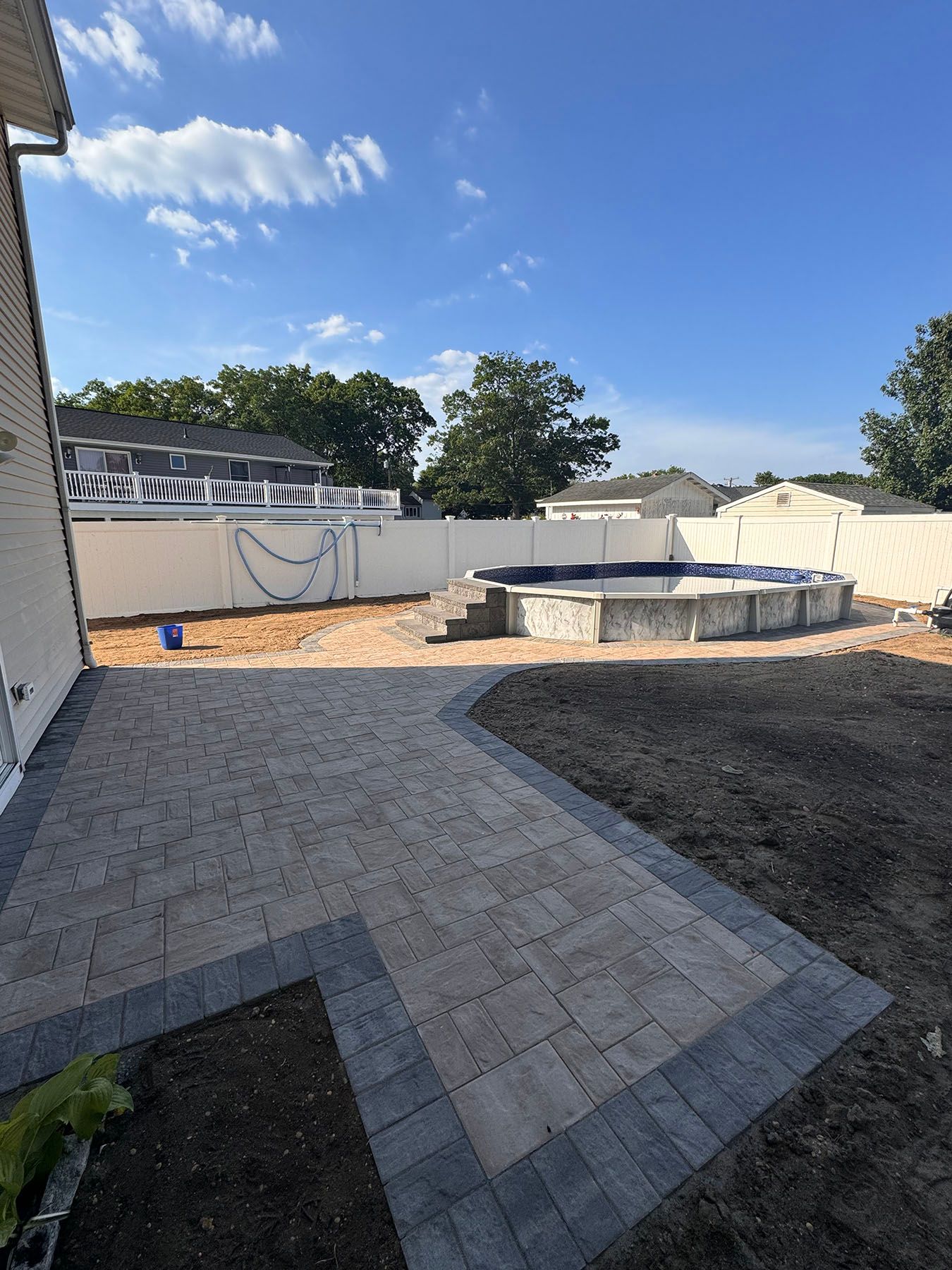 A patio with a pool in the backyard of a house.