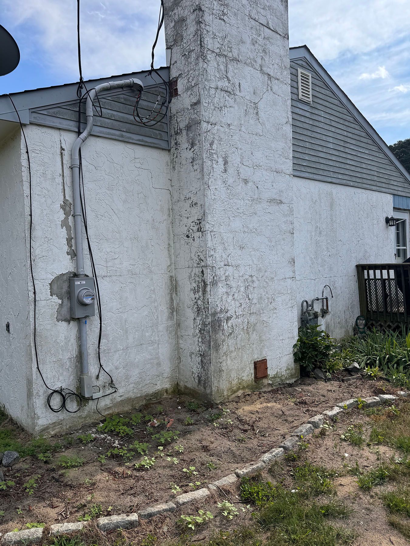 A white house with a chimney on the side of it.