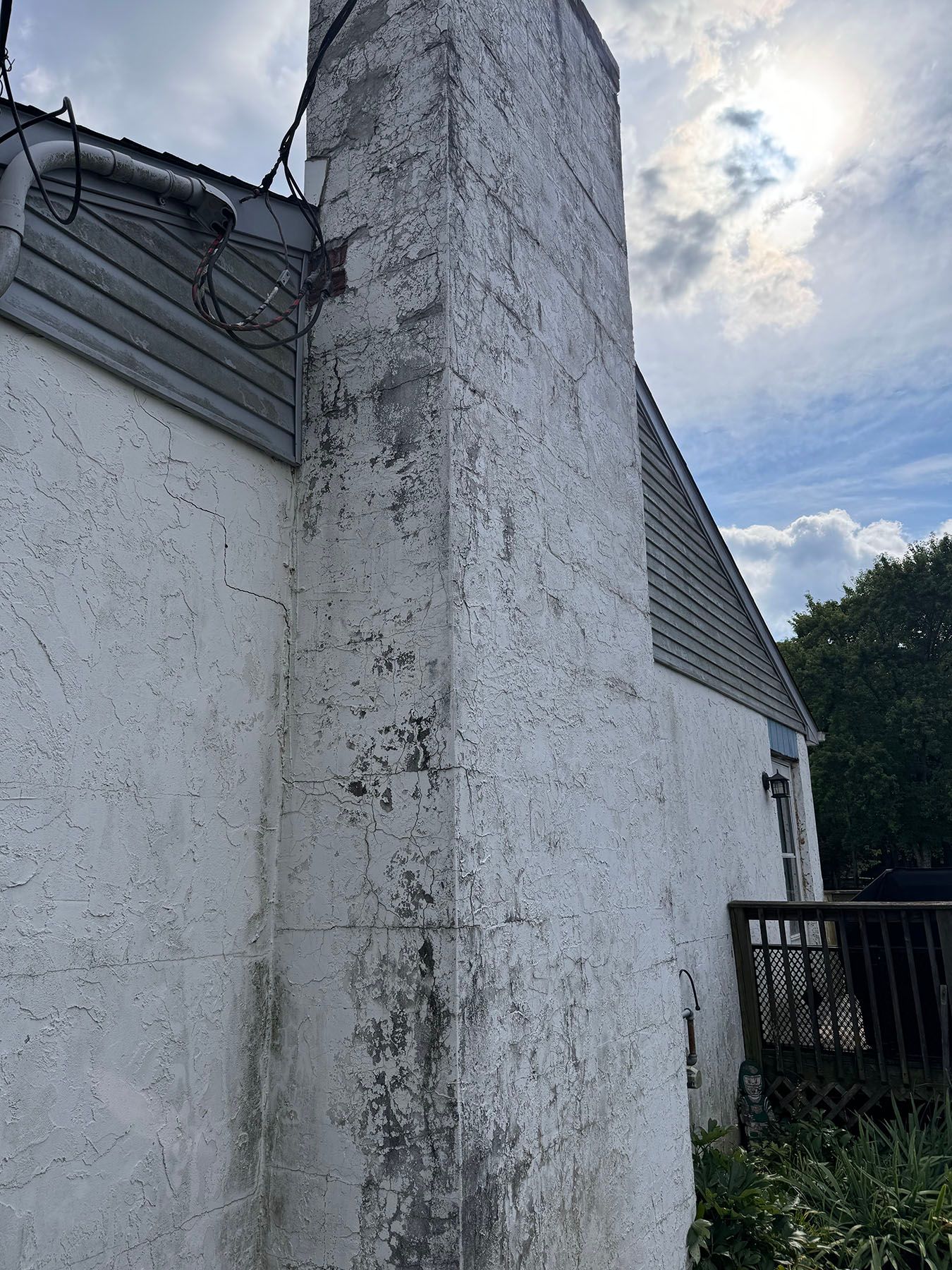 A white building with a chimney on the side of it.