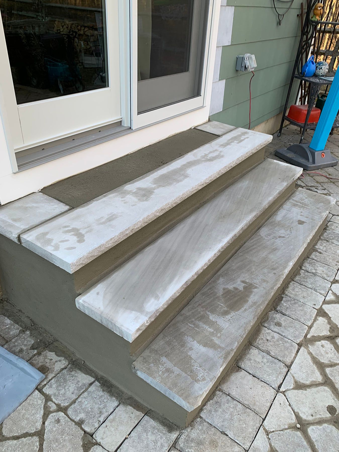 A set of concrete steps leading up to a door.