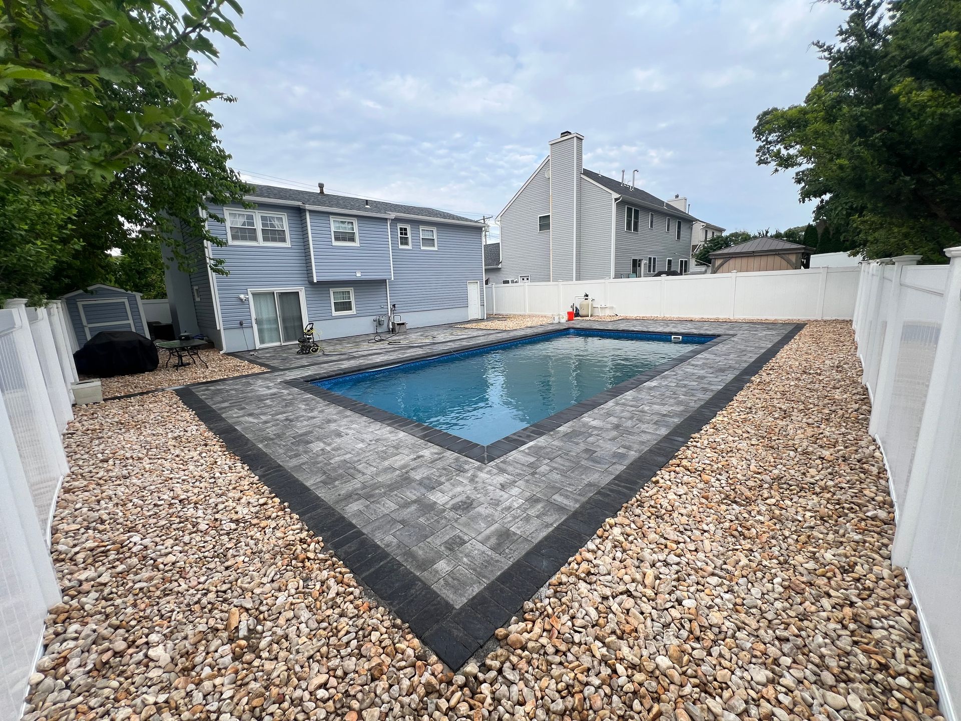 There is a large swimming pool in the backyard of a house.