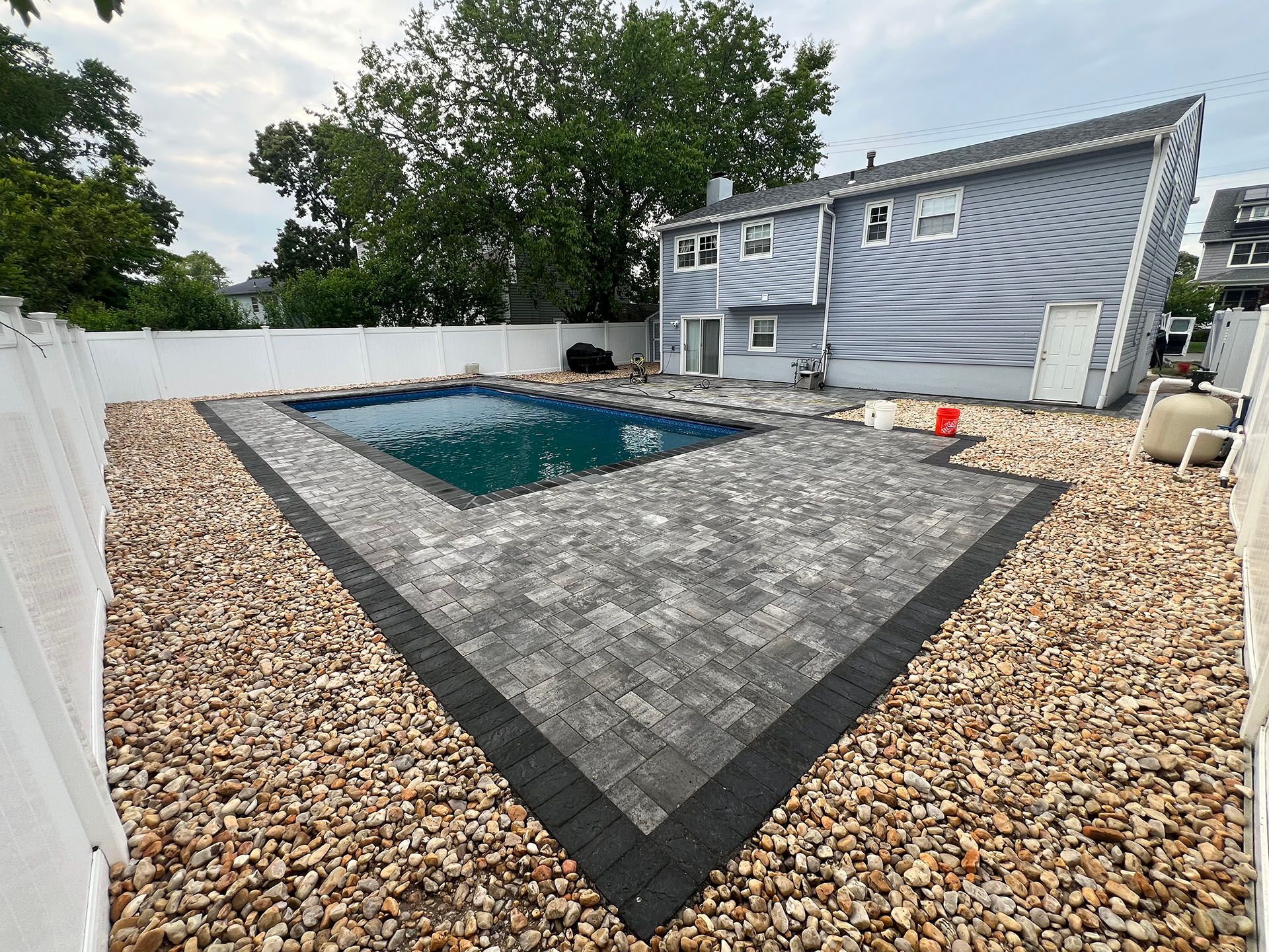 There is a large swimming pool in the backyard of a house.