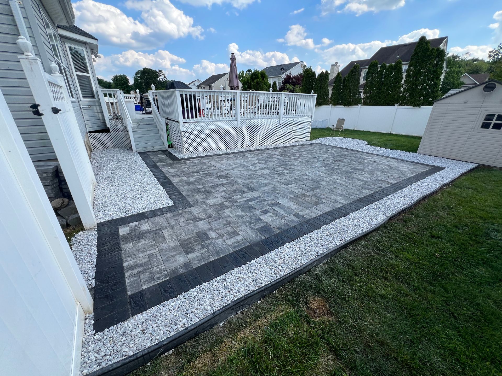 A patio with a deck in the backyard of a house.