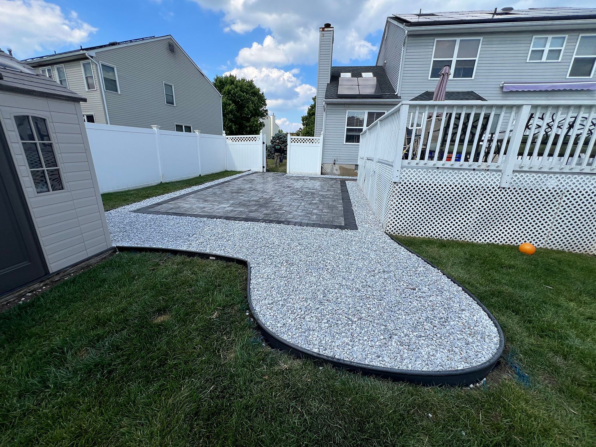 There is a walkway in the backyard leading to a house.