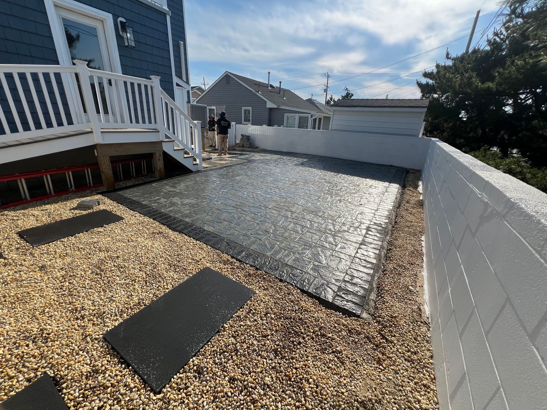 A man is standing in the backyard of a house.