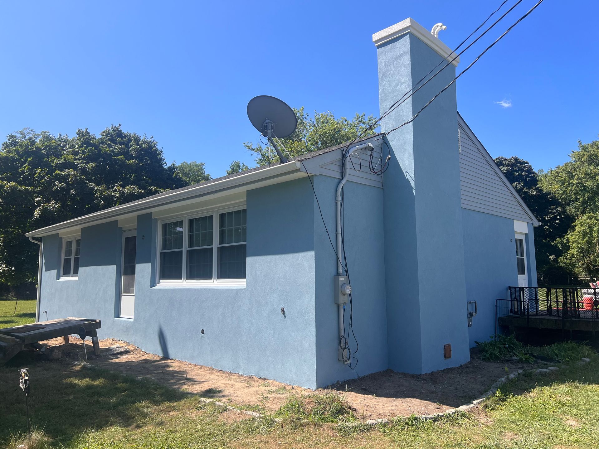 A blue house with a chimney and satellite dish