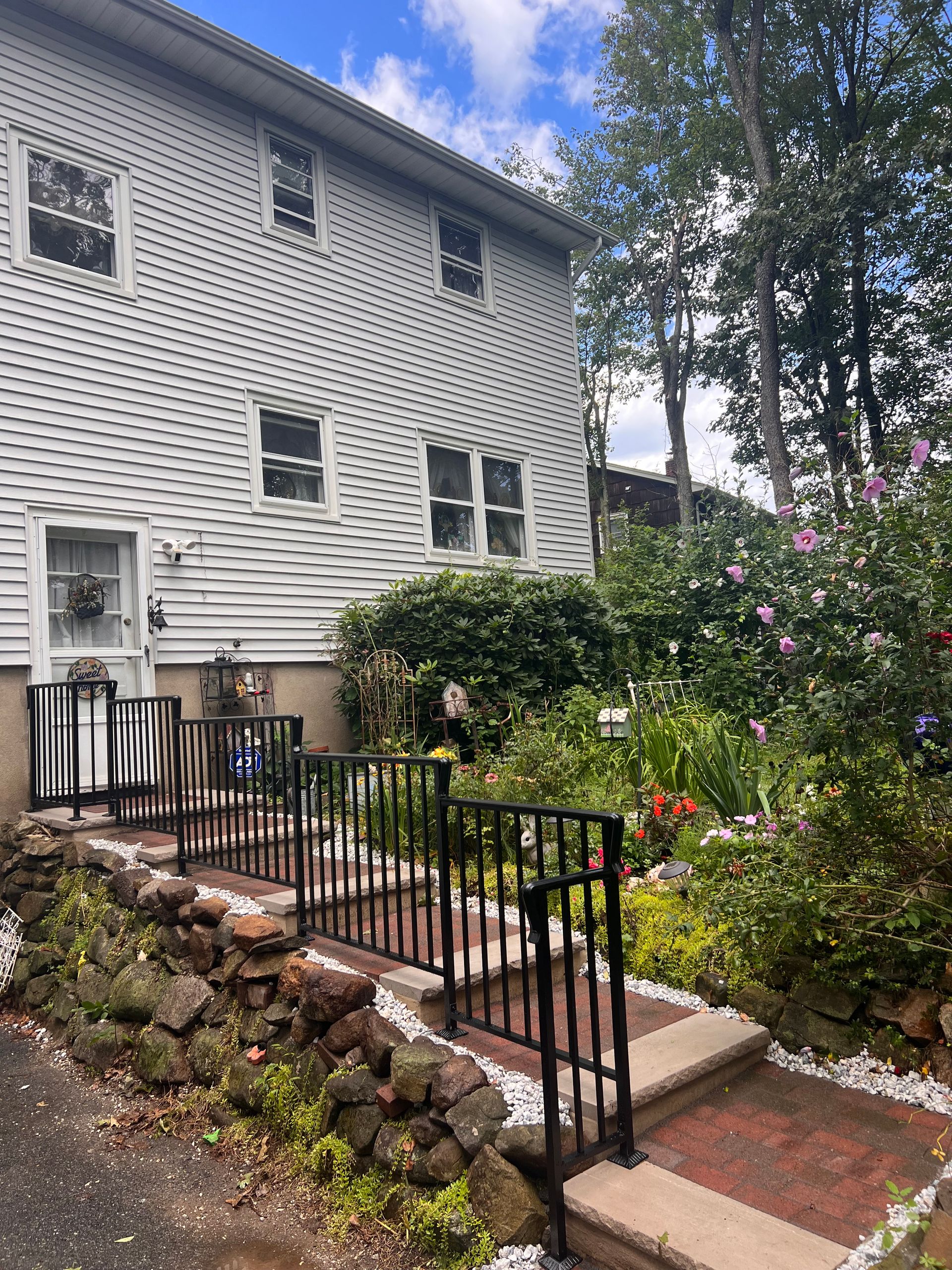 A white house with a garden in front of it.