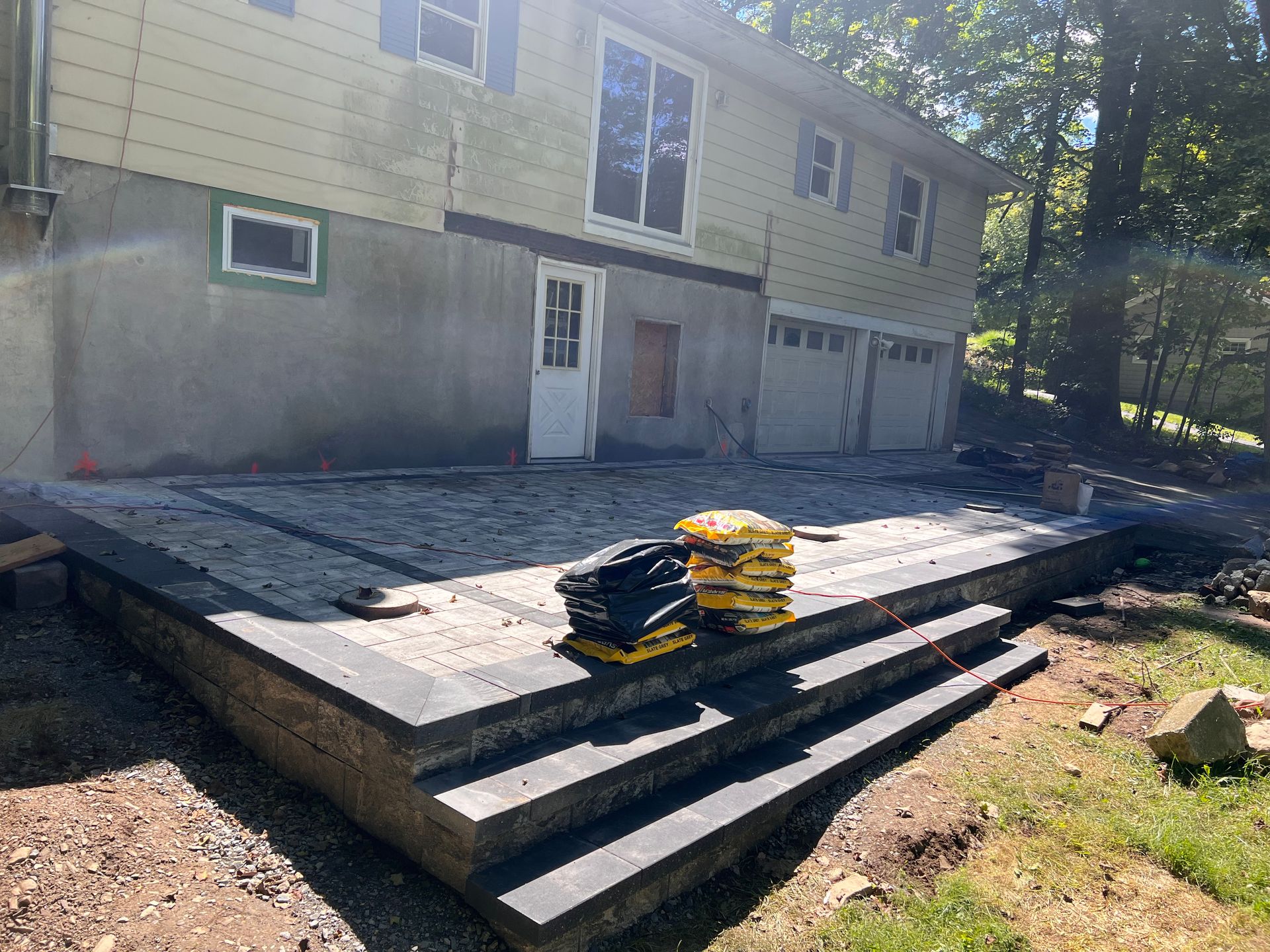 A patio is being built in front of a house.