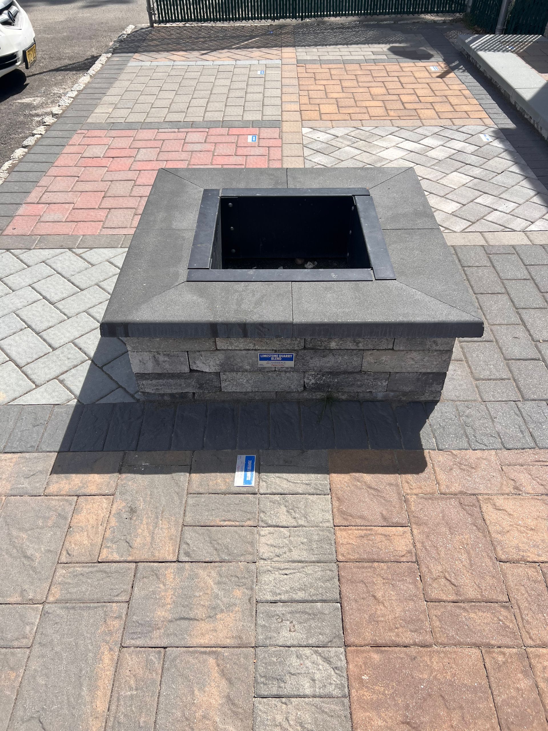 A fire pit is sitting on top of a brick patio.