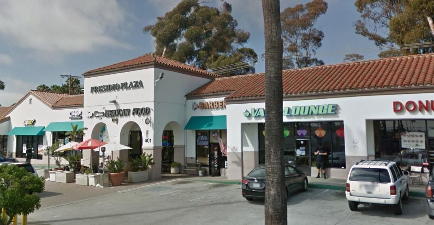 A plaza with shops: The Lachman Food, a bakery, a sandwich shop, and a donut shop with a clay tile roof.