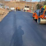 A roller is rolling asphalt on a road.