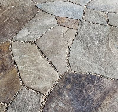 Flagstone patio with irregular stone shapes and gravel joints.