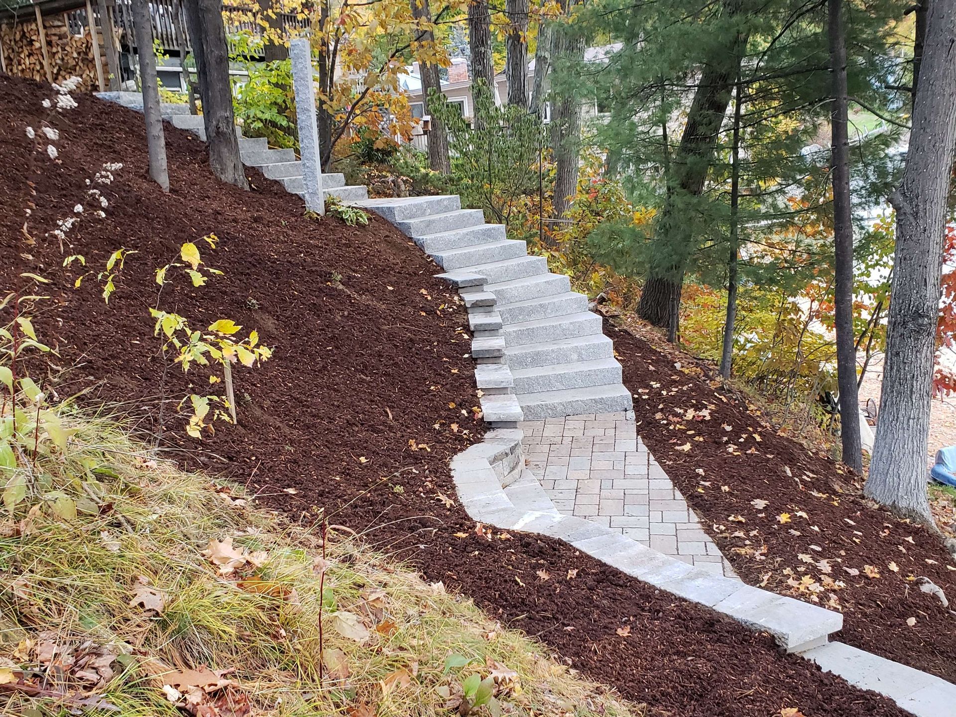 Stone steps ascend a mulch-covered hillside.