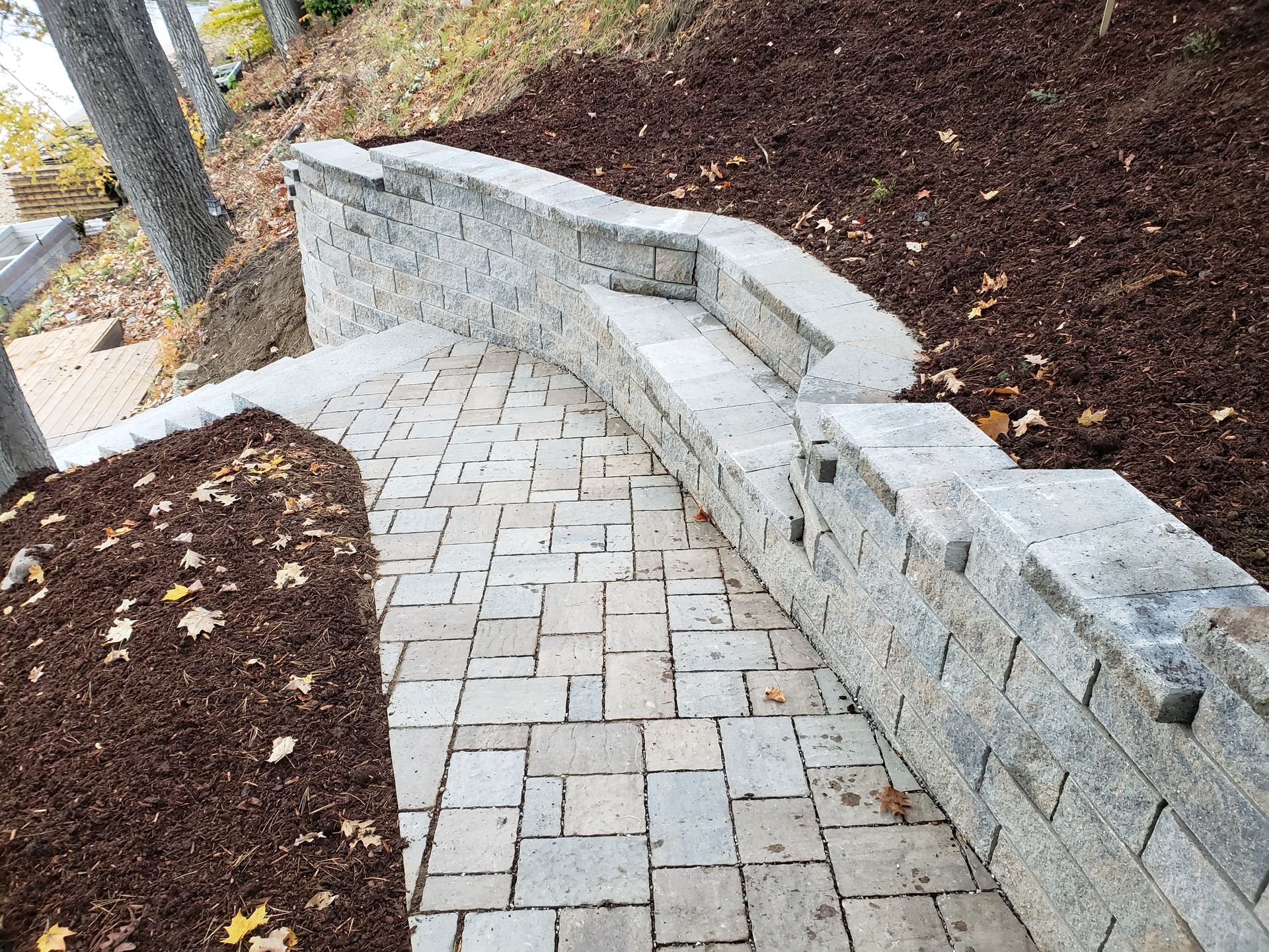 Stone pathway with steps and retaining wall. Mulch on either side.