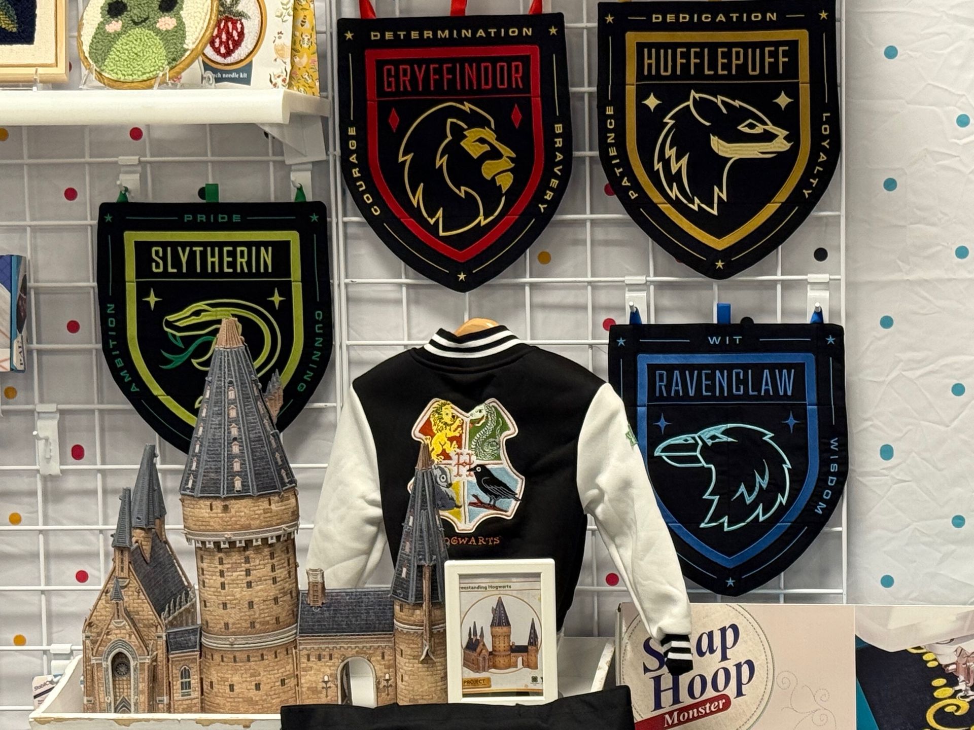 Harry Potter themed display: Hogwarts house banners, jacket, and castle model.