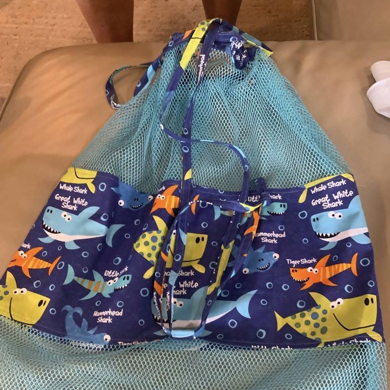 Blue mesh beach bag with a shark-themed fabric overlay.