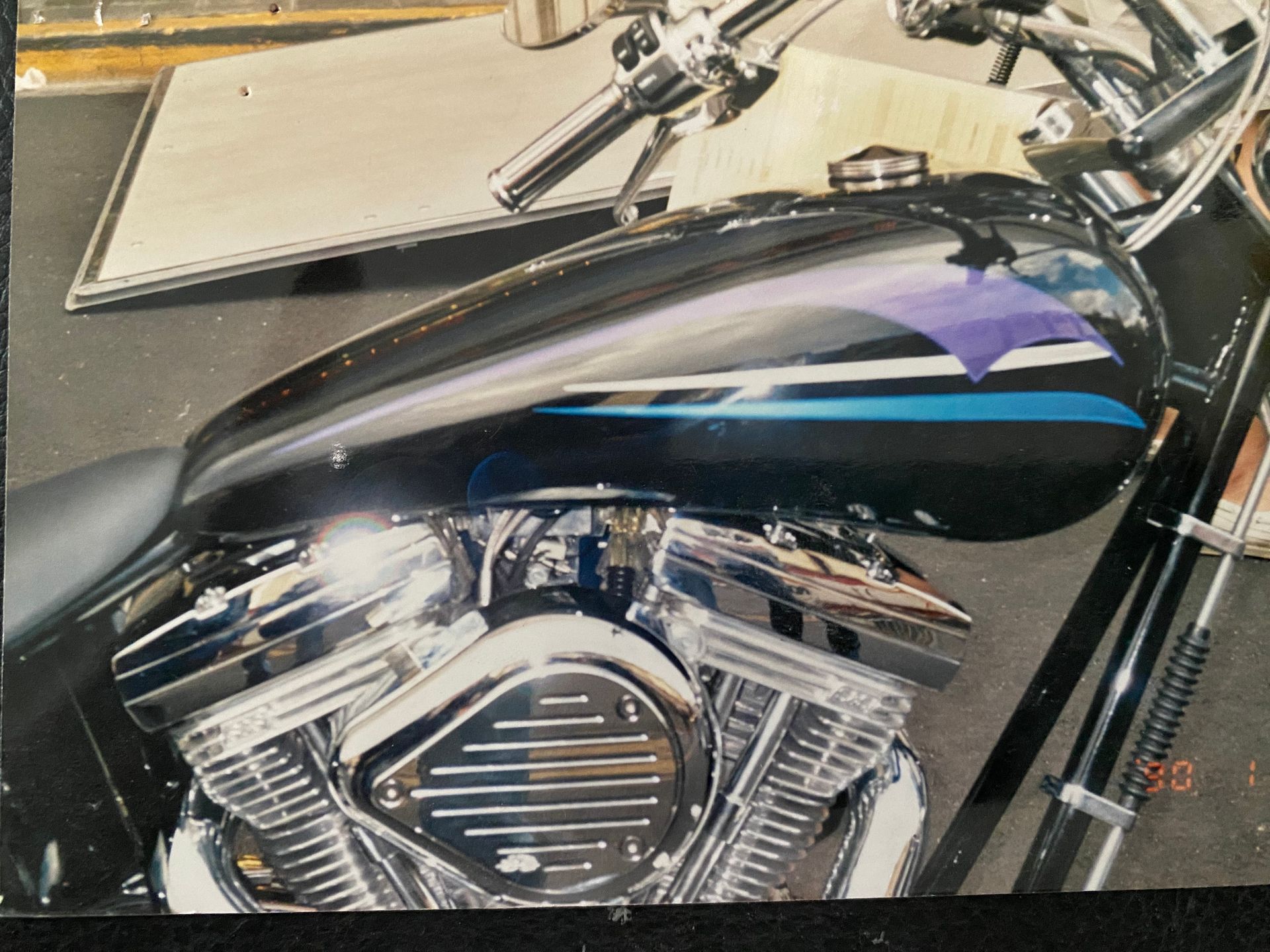 Black and chrome motorcycle gas tank with purple and blue stripes.