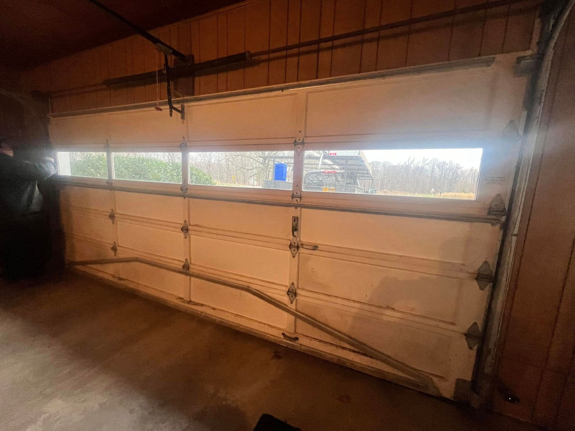 A garage door with a window in it is open.