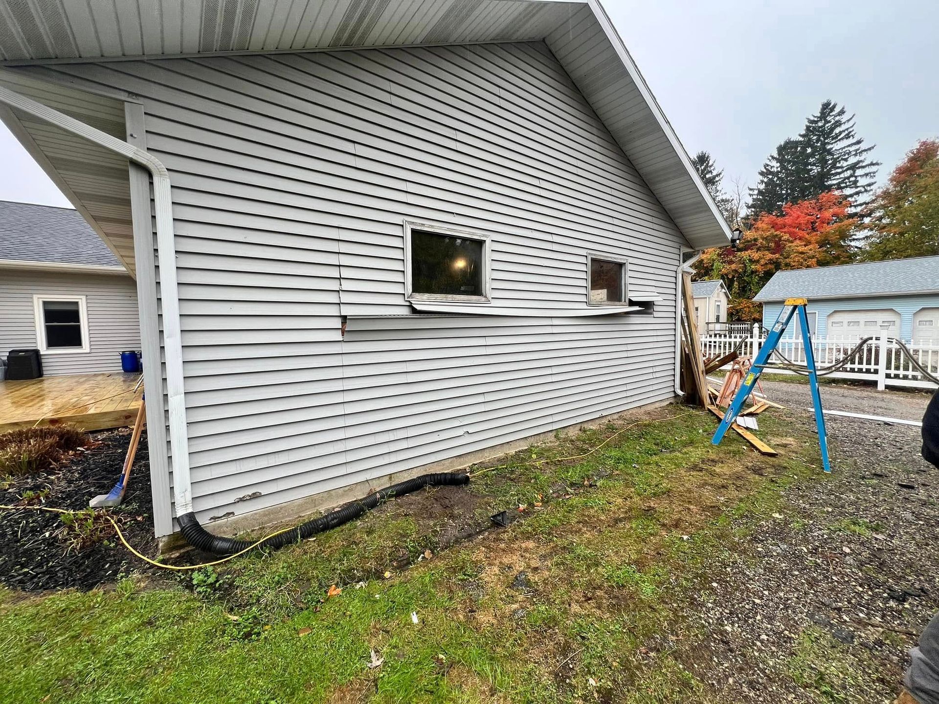 A white house with a swing set in front of it.